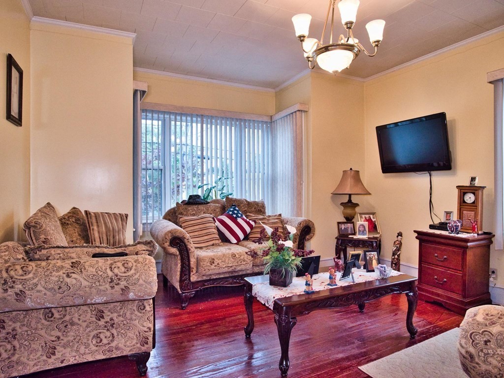 539 Warren Street Fall River, MA 02721 - Photo 7 of 42 a living room with furniture chandelier and a flat screen tv
