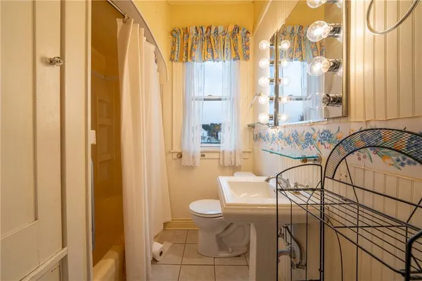 a bathroom with a sink a toilet and shower curtain
