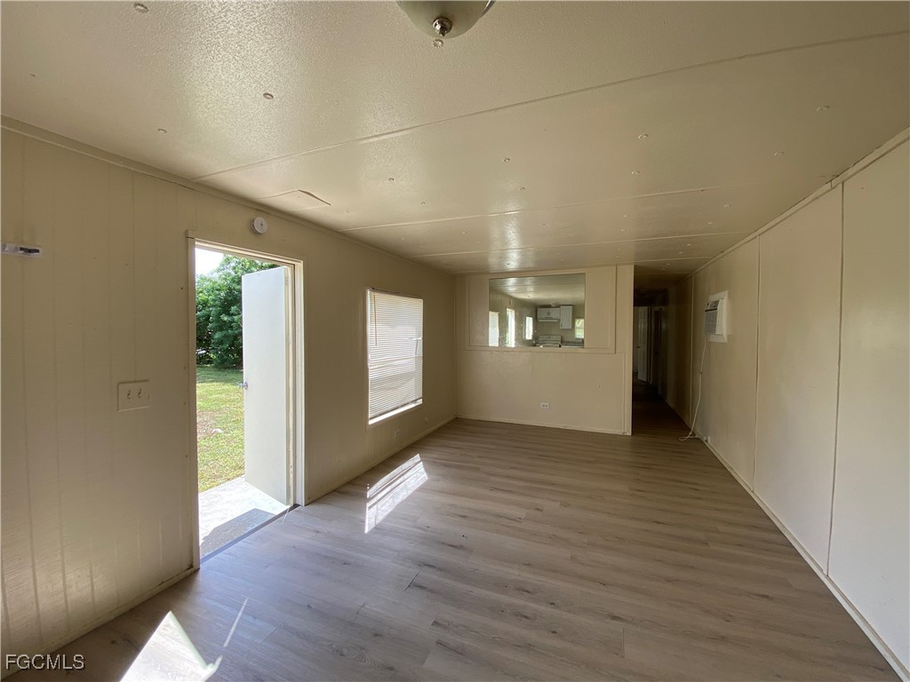 8376 Nault Road North Fort Myers, FL 33917 - Photo 5 of 10 an empty room with wooden floor and windows