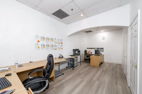 a view of a workspace with furniture and a window