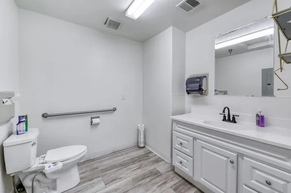 a bathroom with a toilet sink and mirror