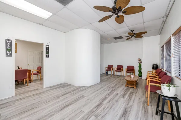 a view of a room with wooden floor and ceiling fan