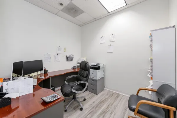 a view of a workspace with furniture and a window