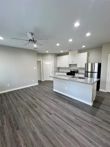 a view of kitchen with granite countertop cabinets and wooden floor
