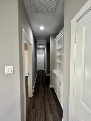 a view of a hallway with wooden floor and closet