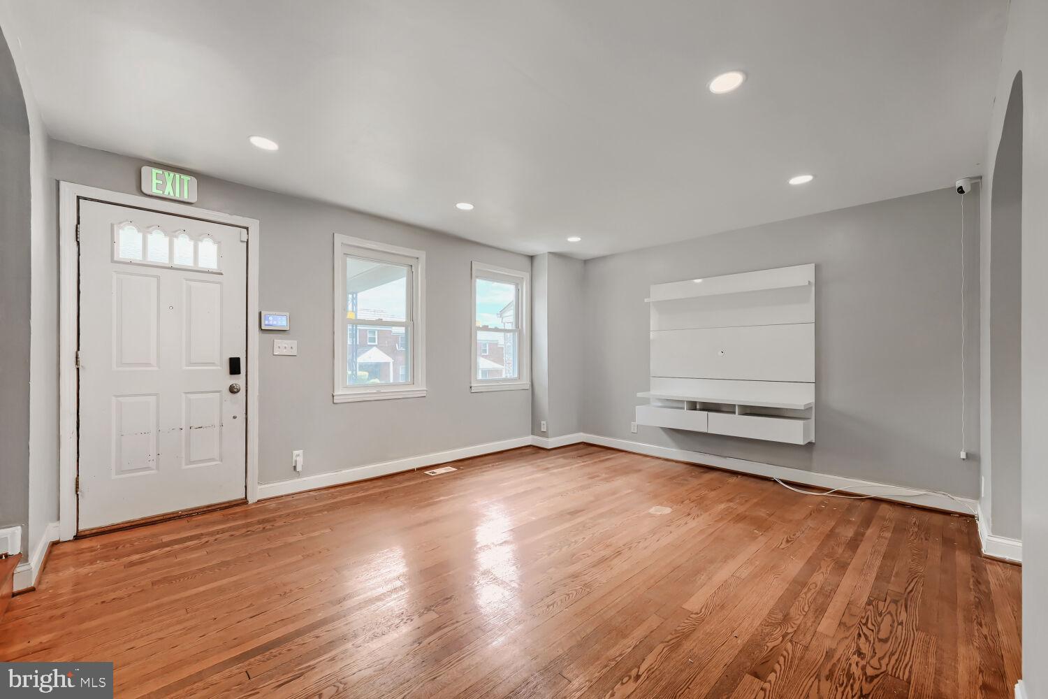 1014 Lyndhurst Street Baltimore, MD 21229 - Photo 6 of 29 an empty room with wooden floor and windows