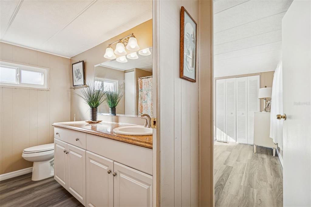 86 Pindo Palm Street West Largo, FL 33770 - Photo 13 of 45 a bathroom with a granite countertop sink mirror and a toilet