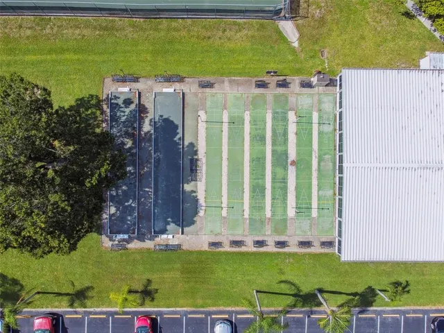 a view of a swimming pool with lawn chairs and plants