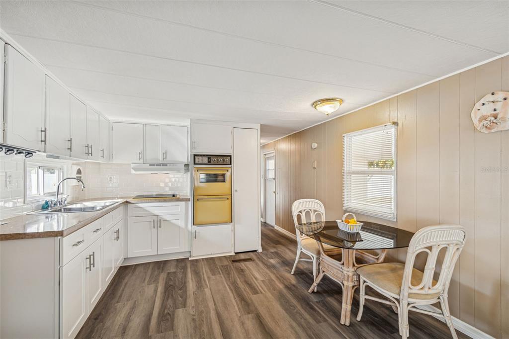 86 Pindo Palm Street West Largo, FL 33770 - Photo 9 of 45 a kitchen with granite countertop a sink cabinets a stove a dining table and chairs