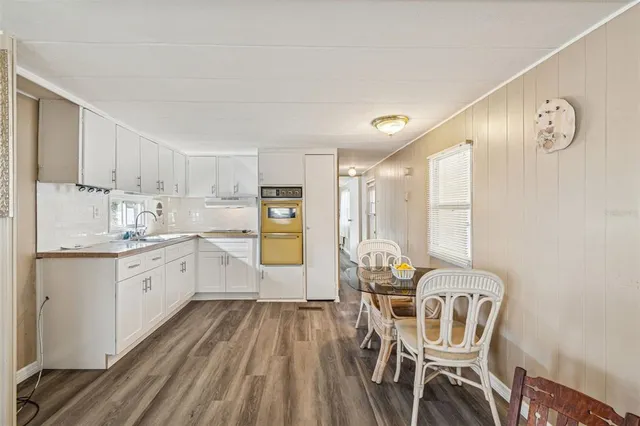 a kitchen with a dining table chairs and white cabinets