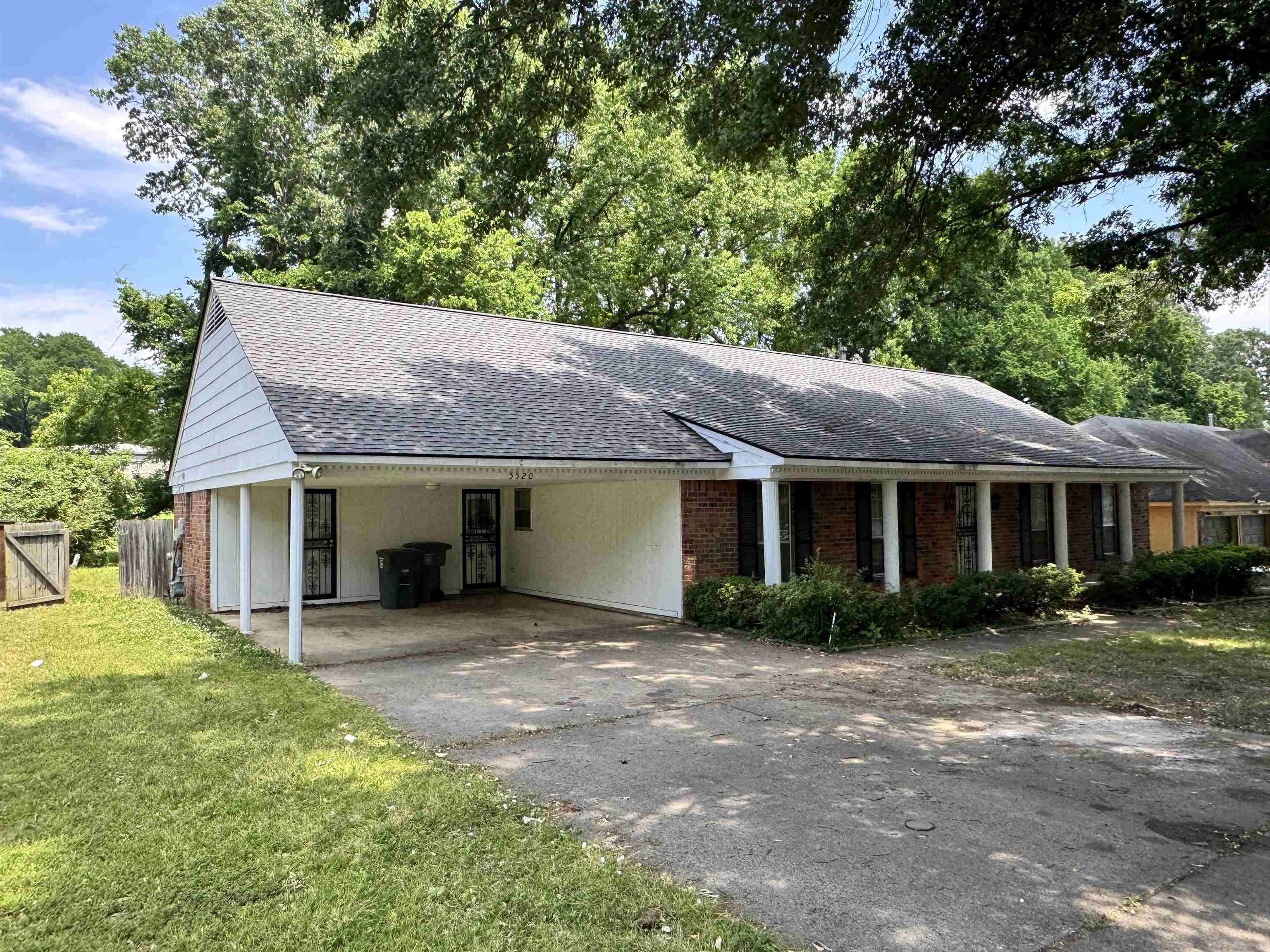 5520 Wagon Rd Gap, Unit GAP Memphis, TN 38134 - Photo 3 of 19 Ranch-style exterior featuring a carport, brick facade, white siding, and a gabled roof