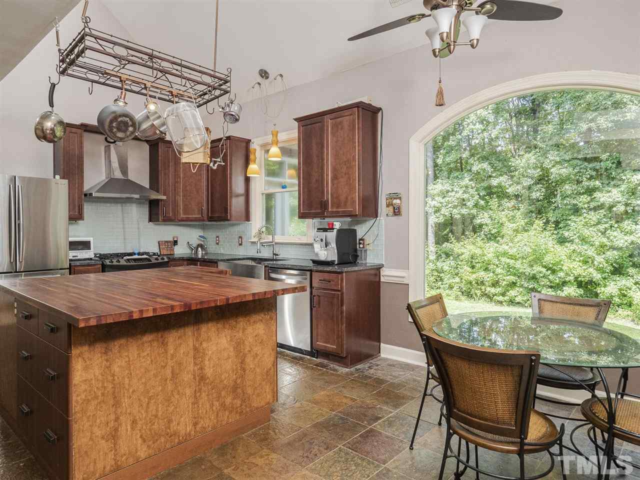552 Tom Wright Road, Unit LO4 Franklinton, NC 27525 - Photo 7 of 30 a kitchen with stainless steel appliances granite countertop a table chairs in it and wooden floors