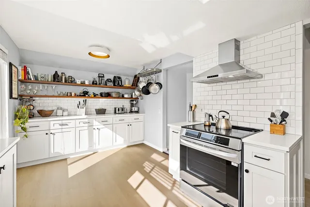 a kitchen with stainless steel appliances a stove a sink and cabinets