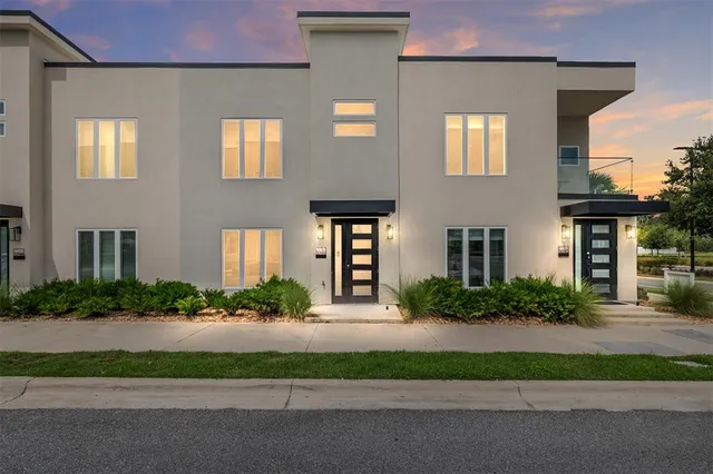 a front view of a house with a yard and plants