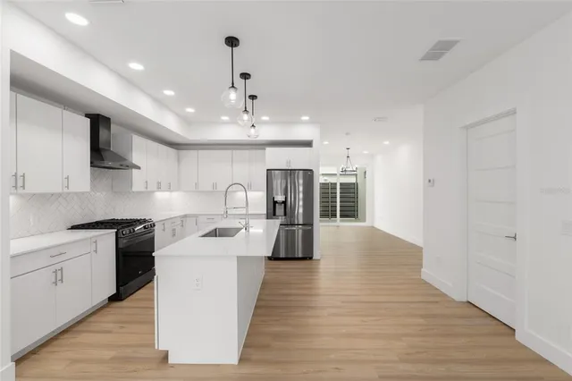 a kitchen with stainless steel appliances granite countertop a sink a stove a refrigerator and a microwave