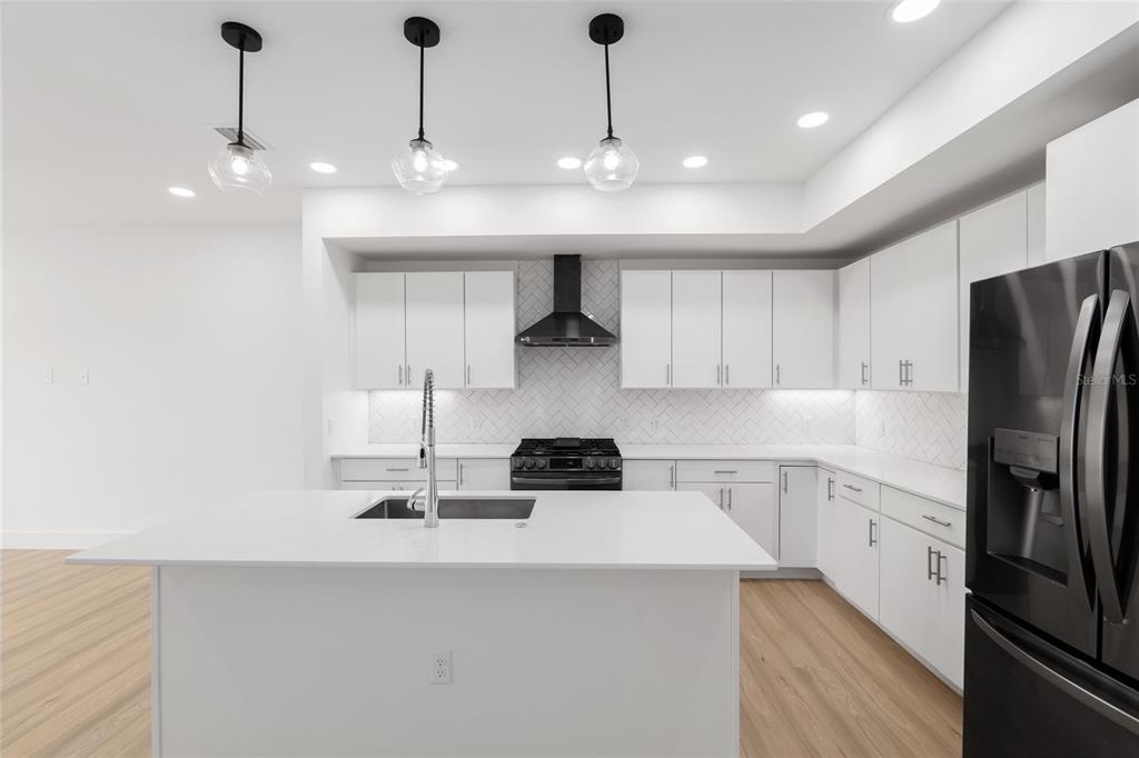 3288 Southwest 49th Terrace Gainesville, FL 32608 - Photo 15 of 71 a kitchen with stainless steel appliances granite countertop a sink a stove a refrigerator and cabinets