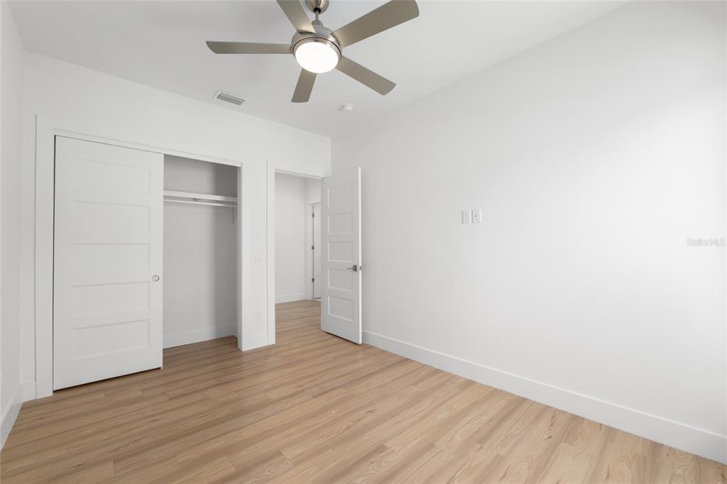 3288 Southwest 49th Terrace Gainesville, FL 32608 - Photo 43 of 71 an empty room with wooden floor and ceiling fan