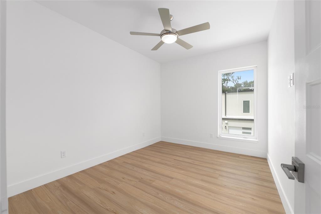 3288 Southwest 49th Terrace Gainesville, FL 32608 - Photo 44 of 71 an empty room with wooden floor ceiling fan and windows