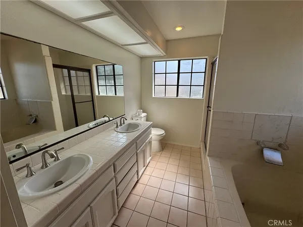 a bathroom with a granite countertop sink a toilet and mirror