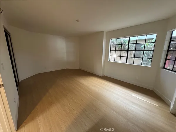 a view of empty room with wooden floor