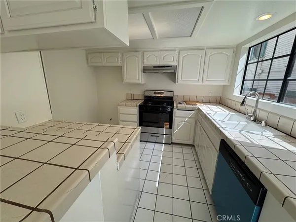 a kitchen with a sink a stove top oven and cabinetry