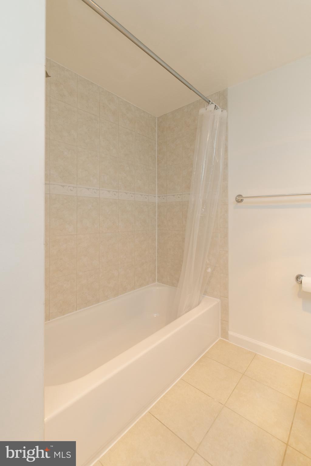 10570 Main Street, Unit 424 Fairfax, VA 22030 - Photo 12 of 18 a bath tub sitting next to a white sink and a shower