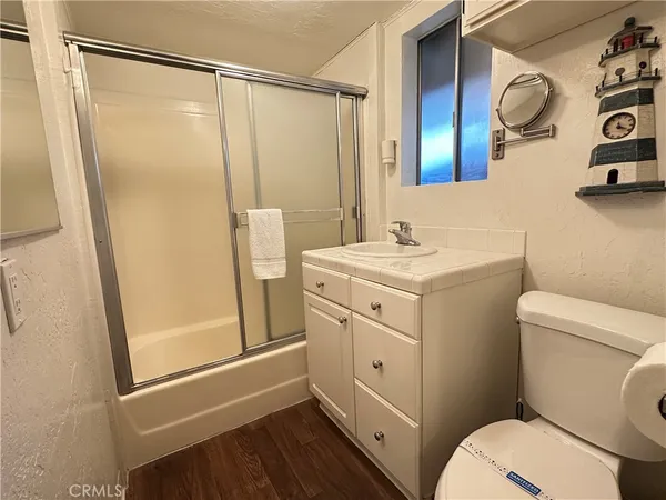 a bathroom with a sink a toilet a mirror and shower