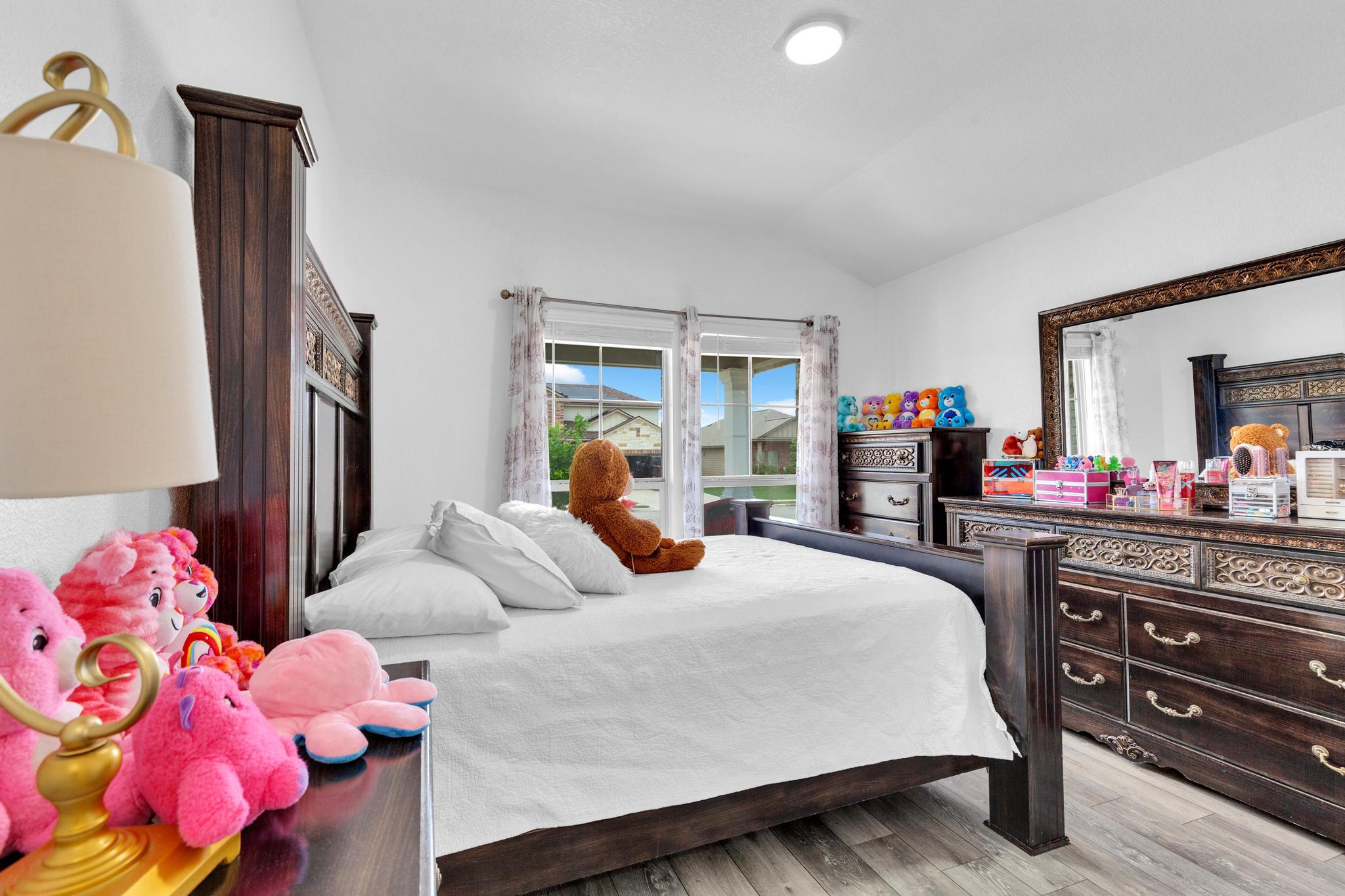 119 Beth Ann Loop Taylor, TX 76574 - Photo 19 of 31 This spacious bedroom offers ample natural light and durable wood flooring.