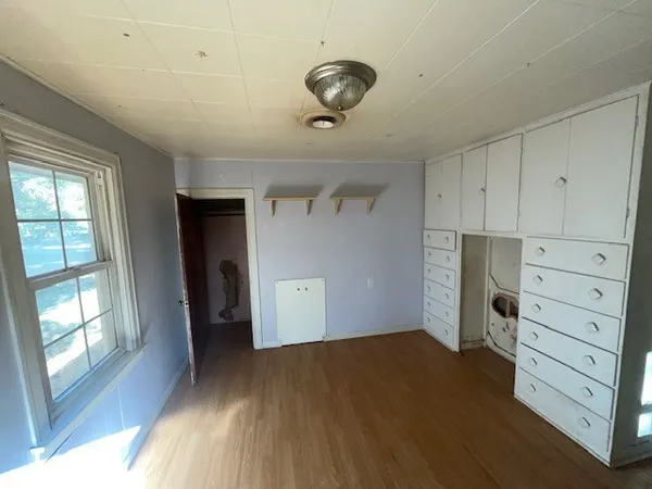 wooden floor in an empty room with a window