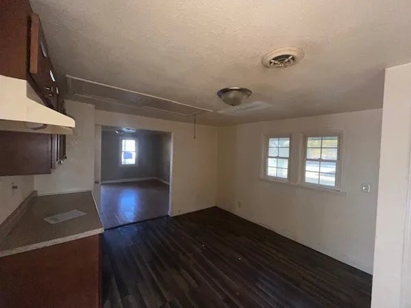 a view of empty room with window and wooden floor