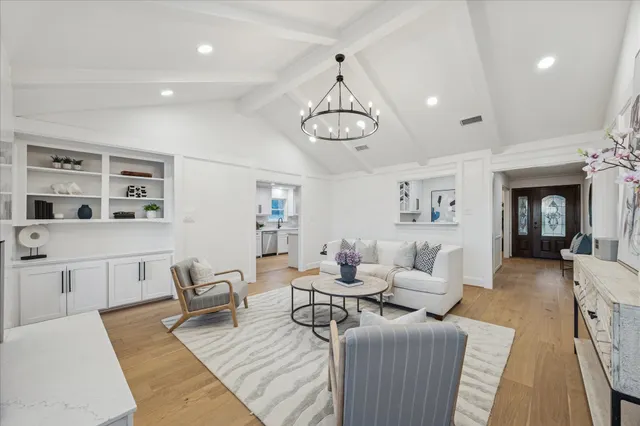 a living room with furniture or chandelier and a wooden floor