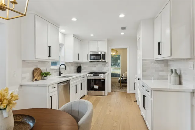 a kitchen with stainless steel appliances granite countertop a stove sink and cabinets