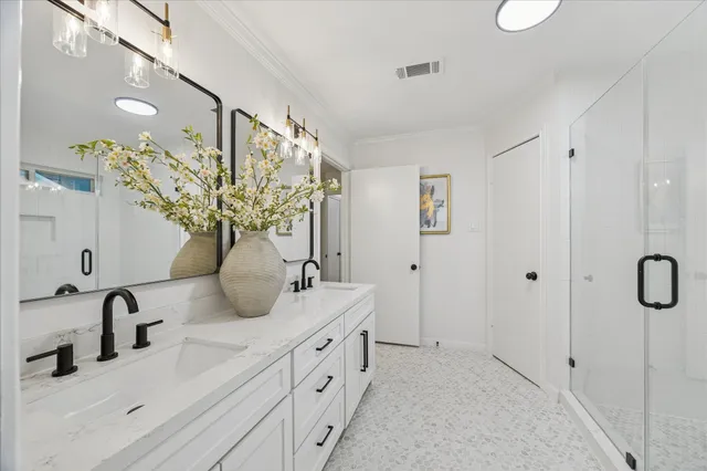 a bathroom with a double vanity sink mirror and shower