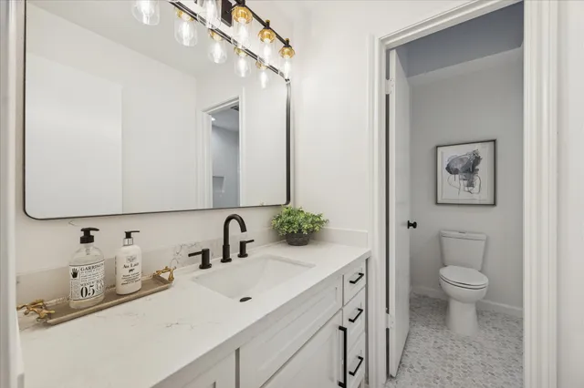 a bathroom with a toilet sink and mirror