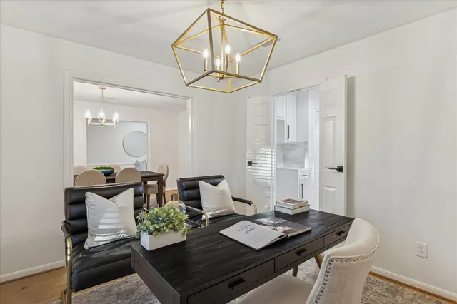 a view of a dining room with furniture a chandelier and wooden floor