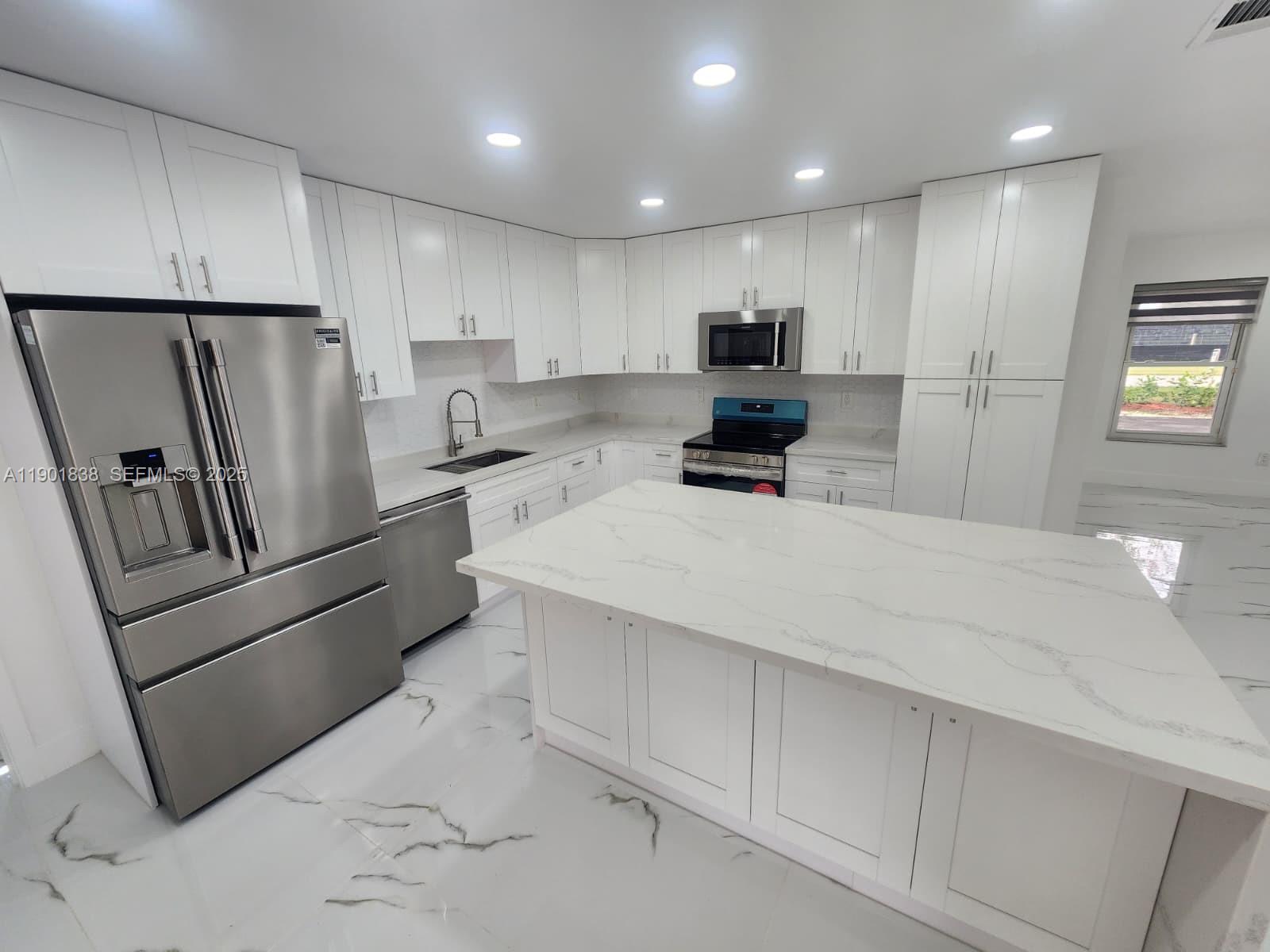 19621 Southwest 308th Street Homestead, FL 33030 - Photo 14 of 31 a kitchen with stainless steel appliances a refrigerator sink and microwave