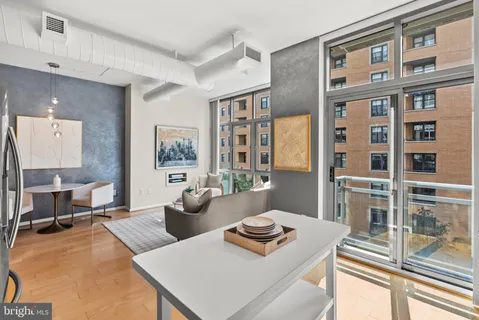 a living room with furniture stove and large window