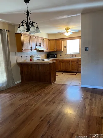 a kitchen with stainless steel appliances granite countertop a sink cabinets and wooden floor