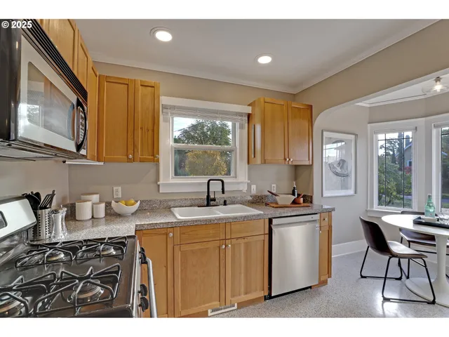 a kitchen with a sink a stove a refrigerator cabinets and dining table