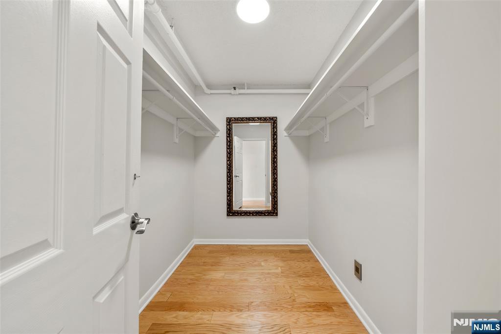 800 Palisade Avenue, Unit 1804 Fort Lee, NJ 07024 - Photo 12 of 23 a view of a hallway with wooden floor and a bathroom