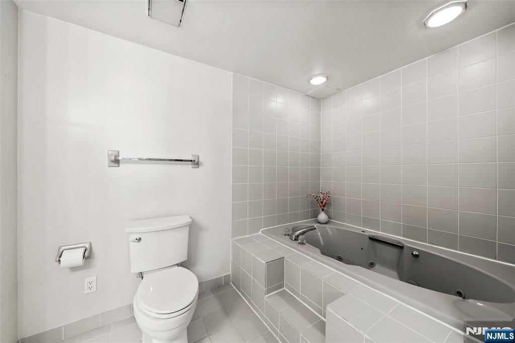 800 Palisade Avenue, Unit 1804 Fort Lee, NJ 07024 - Photo 15 of 23 a spacious bathroom with a bathtub and toilet