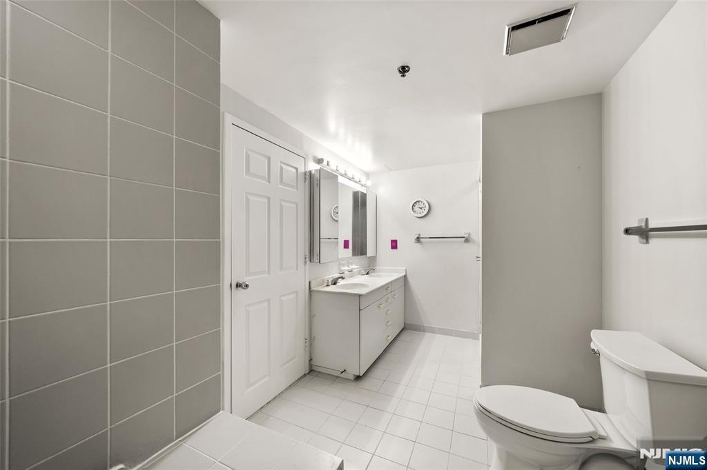 800 Palisade Avenue, Unit 1804 Fort Lee, NJ 07024 - Photo 16 of 23 a bathroom with a sink mirror toilet and shower