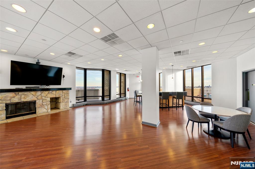 800 Palisade Avenue, Unit 1804 Fort Lee, NJ 07024 - Photo 22 of 23 a view of a living room a dining room wooden floor and a flat screen tv