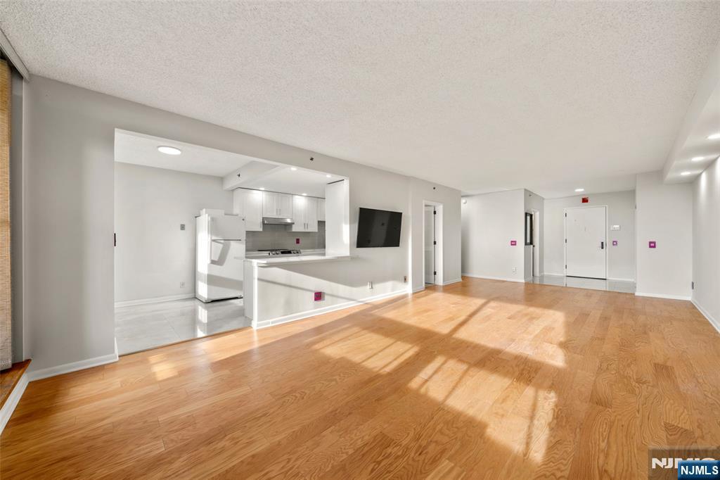 800 Palisade Avenue, Unit 1804 Fort Lee, NJ 07024 - Photo 6 of 23 a large white room with kitchen natural light and wood floor
