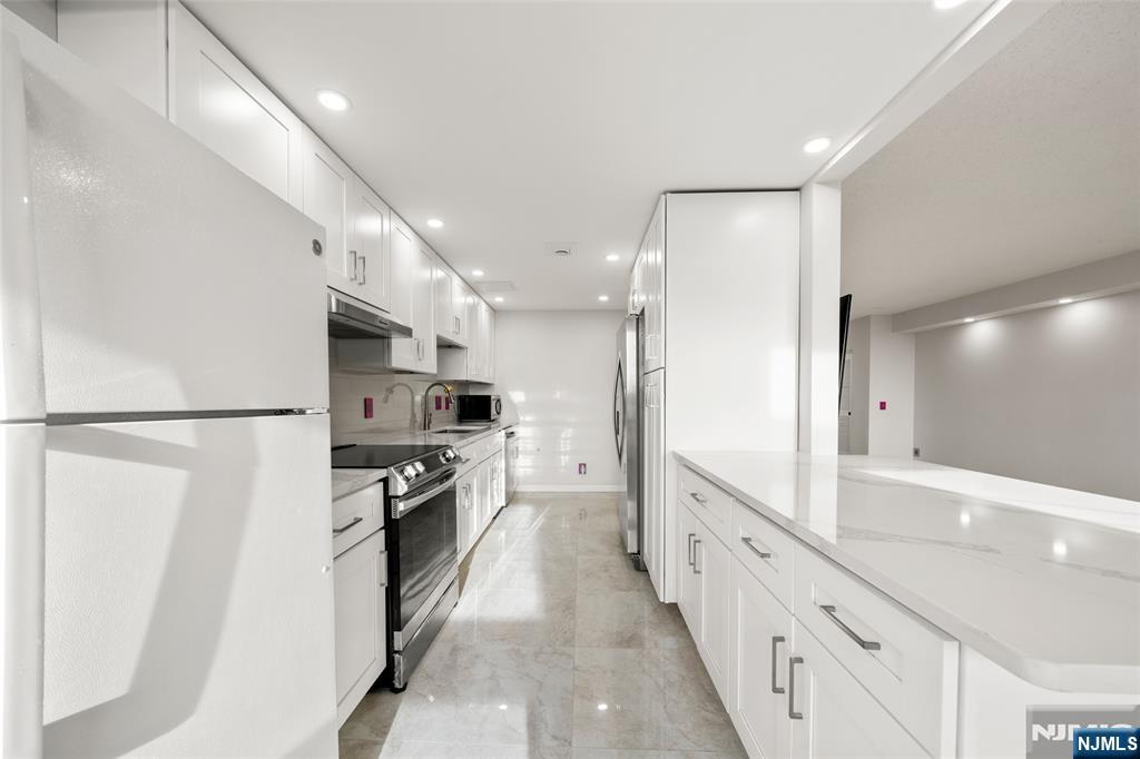 800 Palisade Avenue, Unit 1804 Fort Lee, NJ 07024 - Photo 8 of 23 a large kitchen with stainless steel appliances