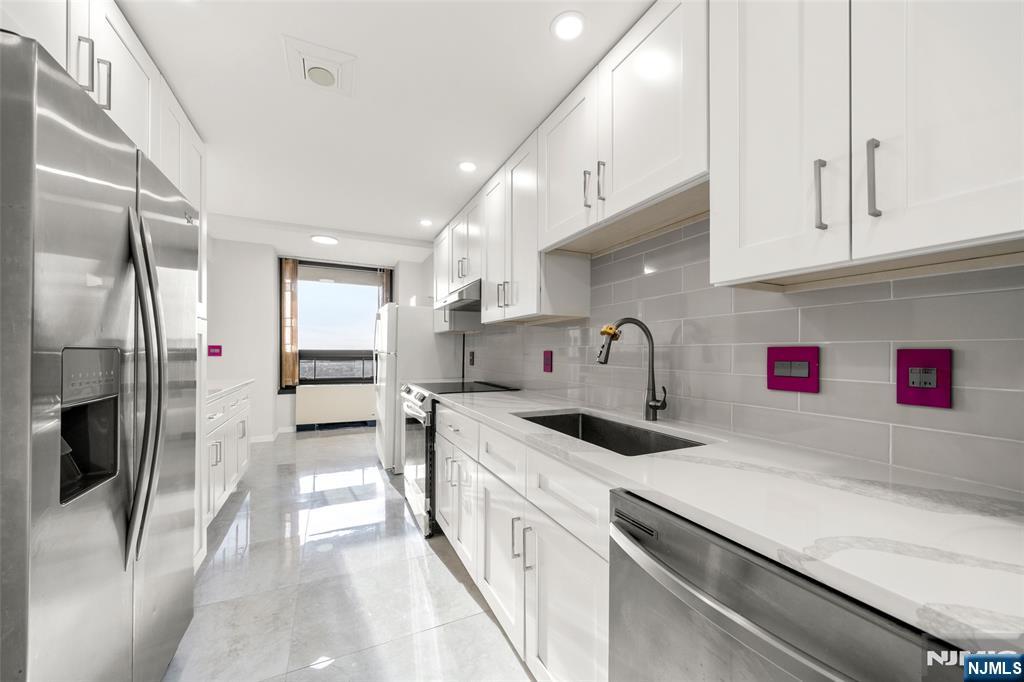 800 Palisade Avenue, Unit 1804 Fort Lee, NJ 07024 - Photo 9 of 23 a kitchen with cabinets a sink and stainless steel appliances