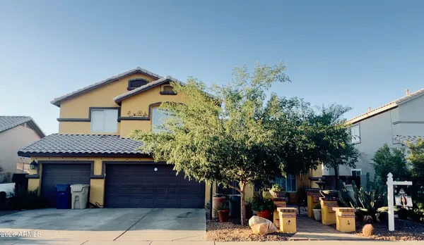 a front view of a house with a tree