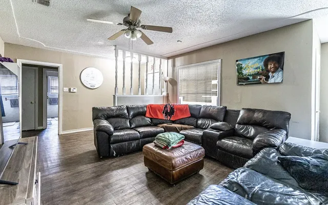 a living room with furniture a large window and a chandelier