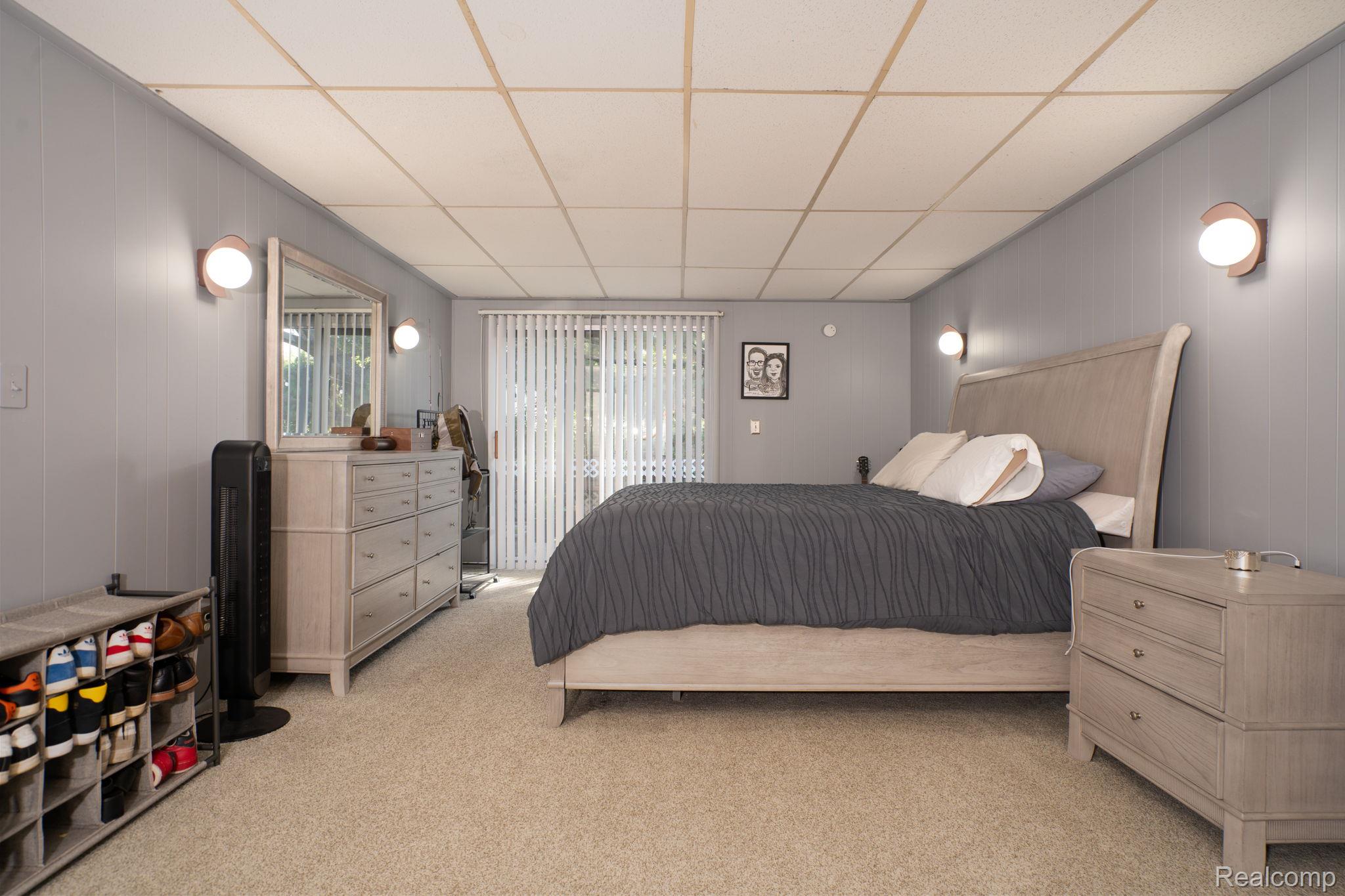 9041 Rackham Street Taylor, MI 48180 - Photo 29 of 34 Carpeted flooring with wall paneling, ceiling tiles, and wall-mounted lighting fixtures