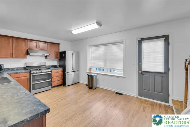 a kitchen with stainless steel appliances granite countertop a stove a sink and a microwave